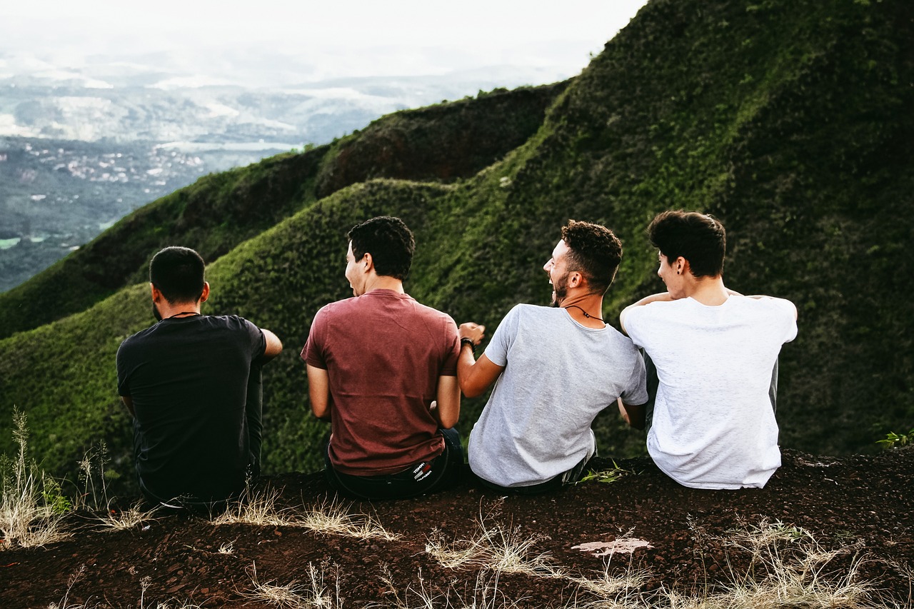 4 Männer sitzten auf einem Berg und lachen