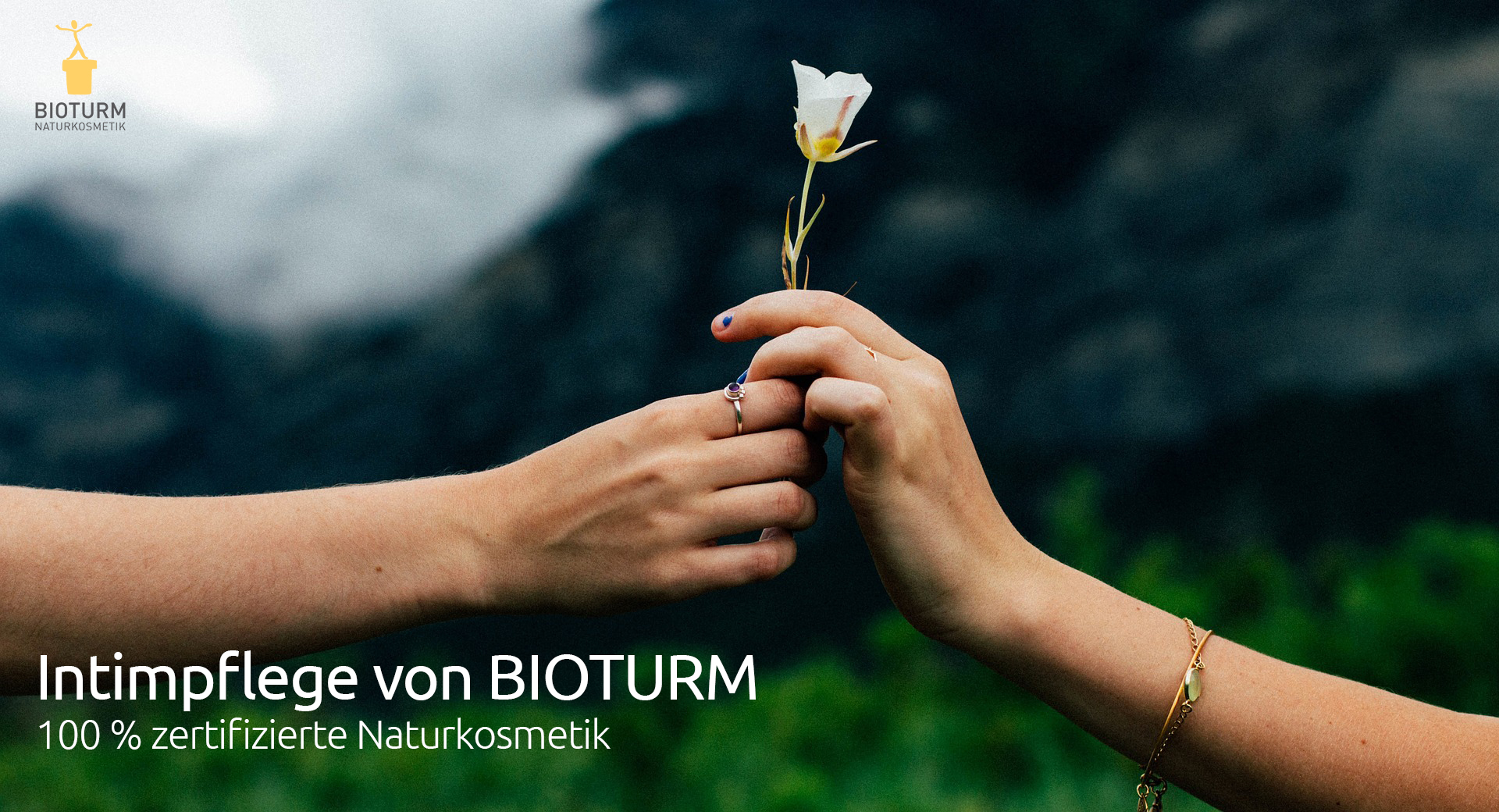 Zwei Hände halten eine weiße Blume mit dem Logo von BIOTURM